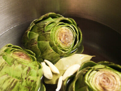 artichokes in pot with water and garlic 