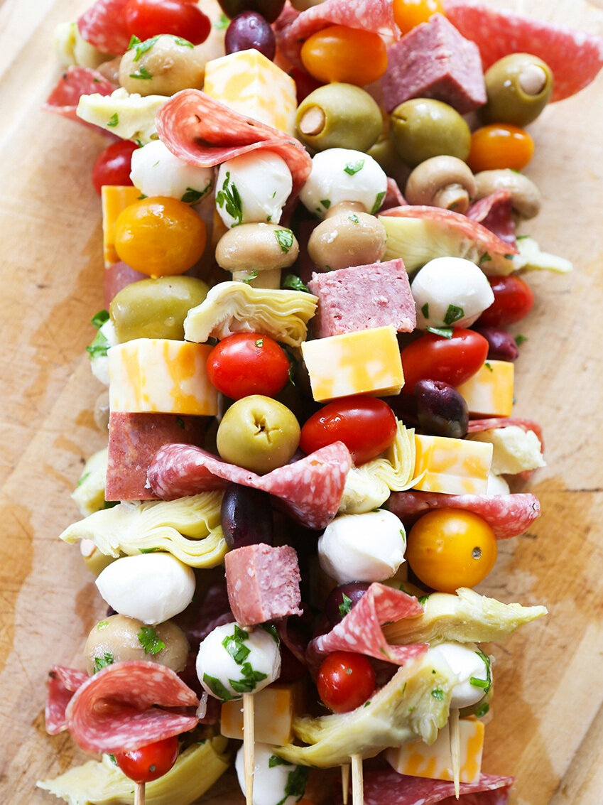 antipasto skewers stacked on a cutting board 