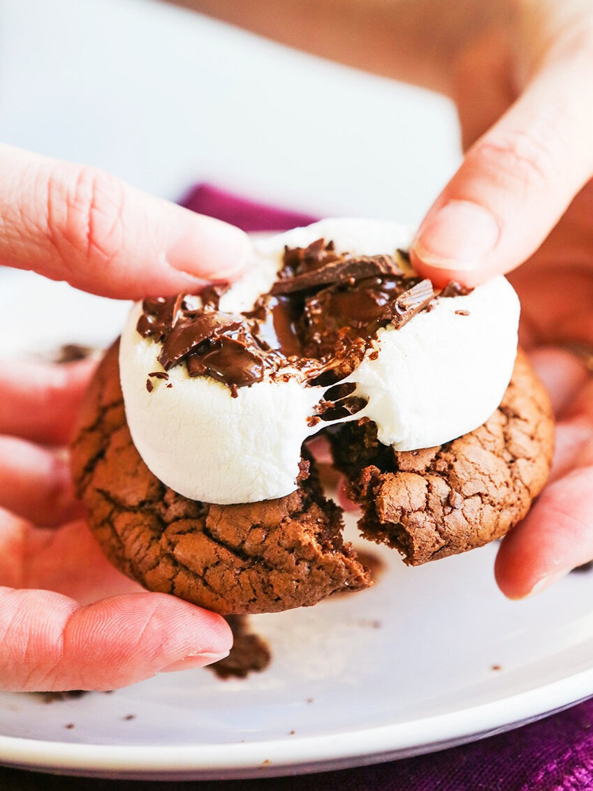 hands pulling apart a gooey hot cocoa cookie 