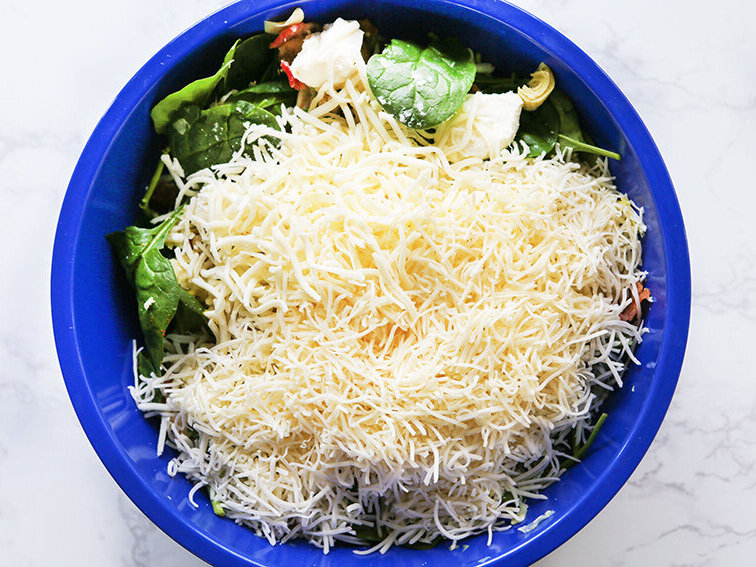  shredded mozzarella piled on ingredient in mixing bowl 