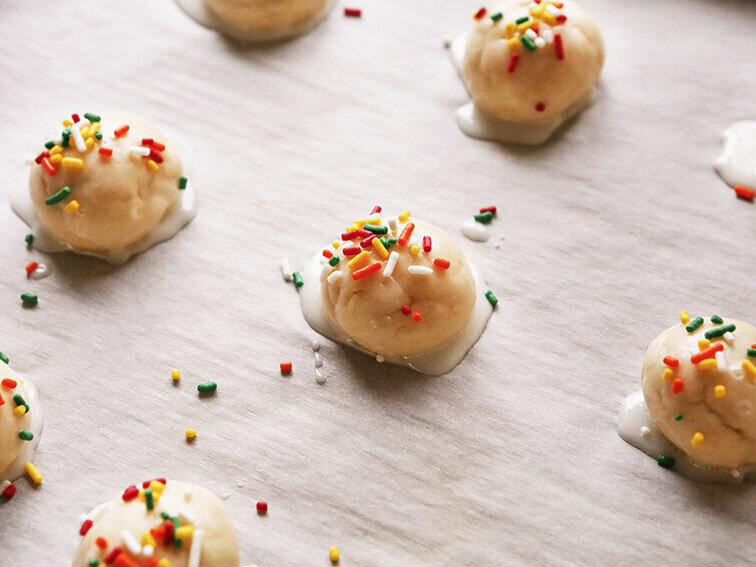 Cookies on parchment with glaze and sprinkles 