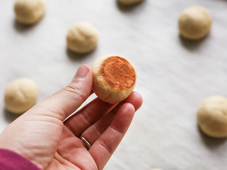 Hand showing the bottom side of a cookie lightly browned 