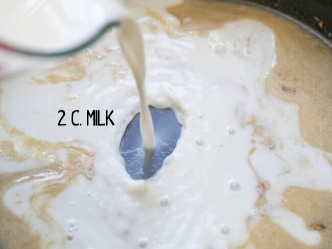  milk being poured into skillet with roux 