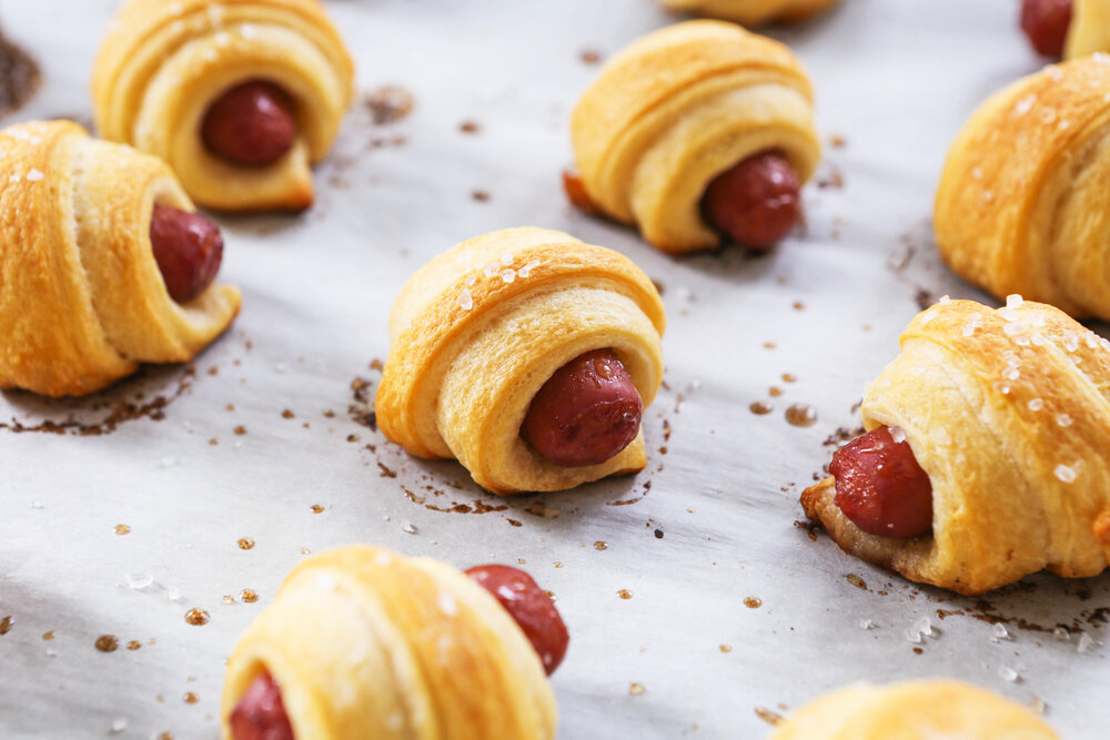 Pigs in a blanket on parchment just out of the oven