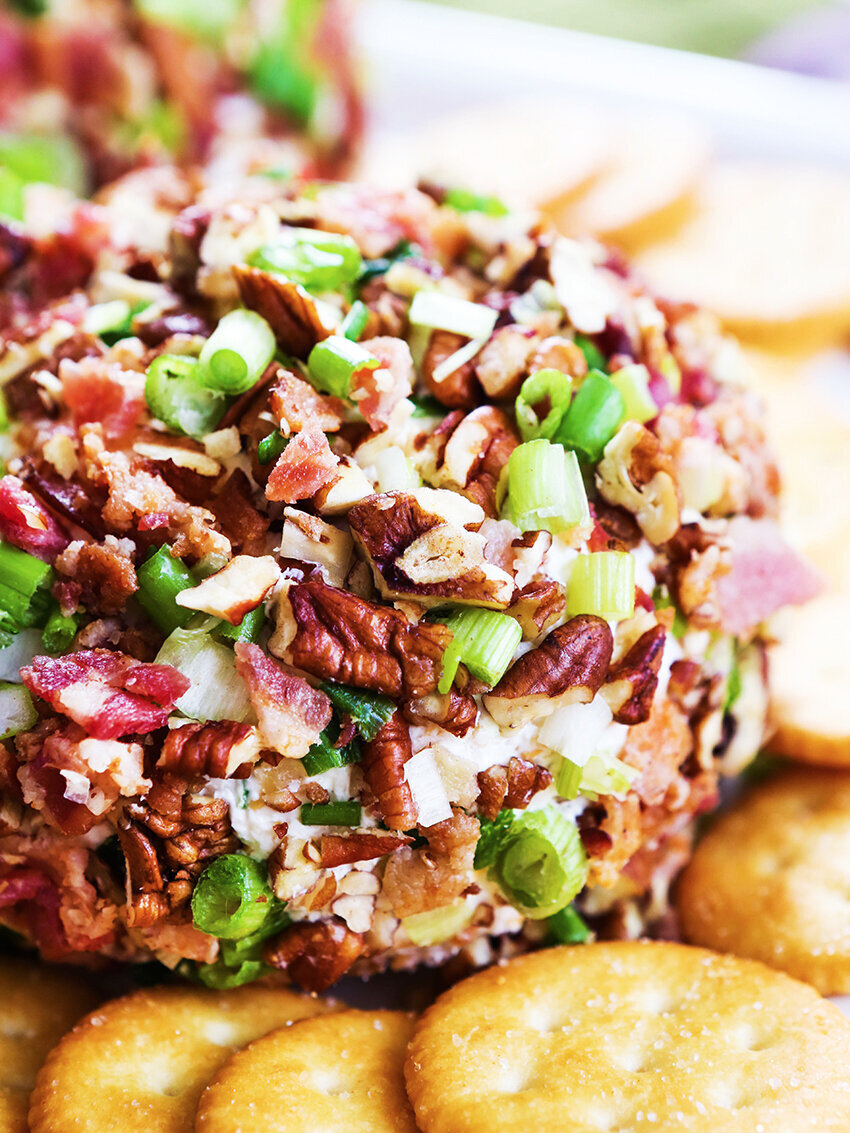 Close up of cheese ball coated in bacon and green onions