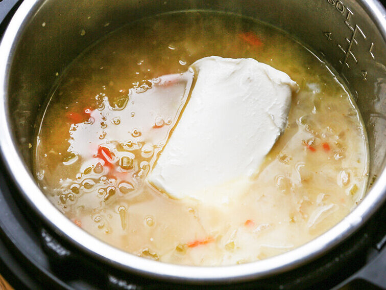 block of cream cheese plopped into potato soup 