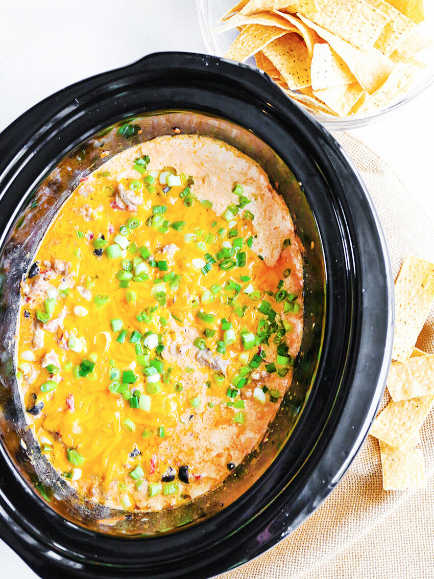  Top view of cheesy dip in a crockpot with tortilla chips 