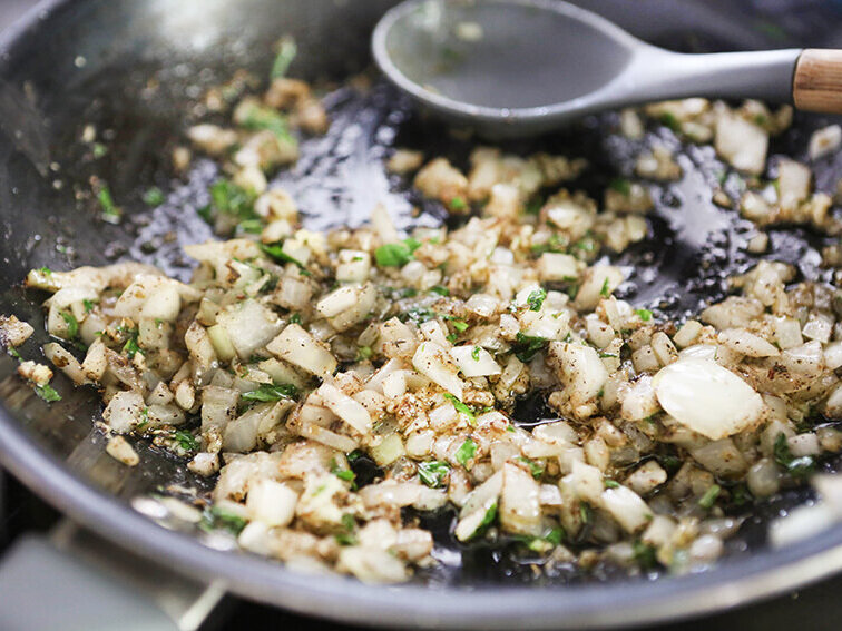 skillet with onions, garlic and basil