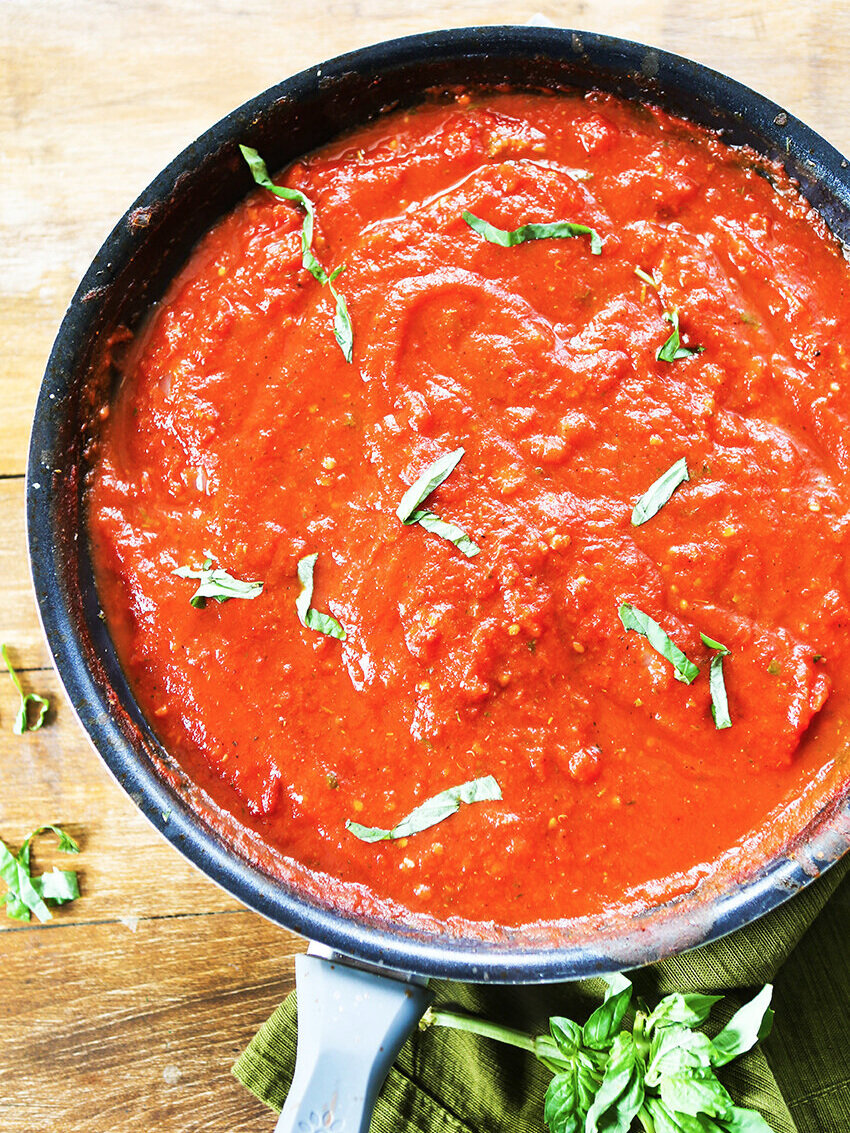 looking into skillet of marinara with chopped basil on top