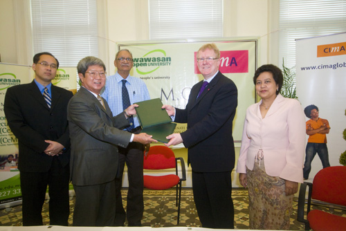 Prof Wong (2nd from left) exchanges the document with Jelly (2nd from right) witnessed by Chet Singh (centre), Dr Seah (left) and Sopiah (right).