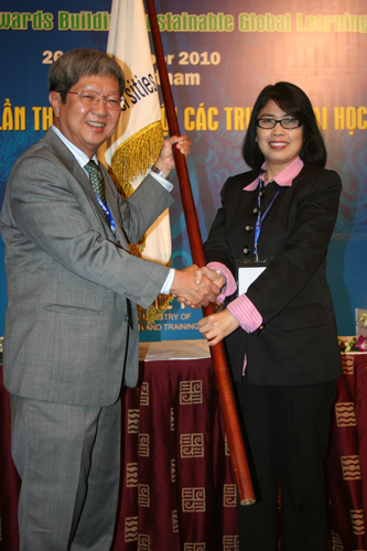 Symbolic handover of flag to Prof Wong (left).