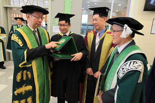 Dr Koh reads the inscription on Chan's (2nd from left) award.