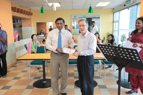 Prof Ho presenting the cheque to Dr Balakrishnan.