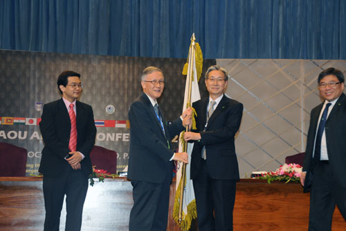 Prof Ho hands over the AAOU flag to Prof John Leong of OUHK.