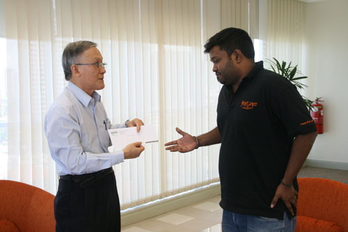 Prof Ho presents the cheque to Sanjeevan.