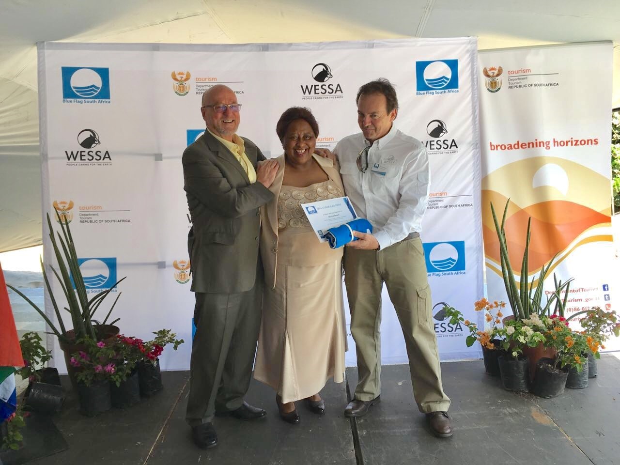 Figure SEQ Figure \* ARABIC 1 : The mayor of Ray Nkonyeni Municipality, Nomusa Mqwebu (Centre) receiving the Blue Flag awards for all seven beaches within the municipality from the Minister of Tourism Dereck Hanekom (Left) and WESSA CEO Dr Thommie Burger (Right).