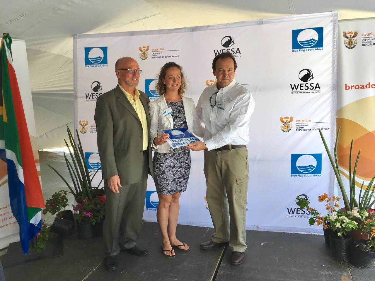 Figure SEQ Figure \* ARABIC 4 : Monica Taylor (Centre) from offshore adventures receiving the Blue Flag award for Sustainable Boating Tourism Operators for their vessels Robberg Express and Oceanic Express from the Minister of Tourism Dereck Hanekom (Left) and WESSA CEO Dr Thommie Burger (Right).