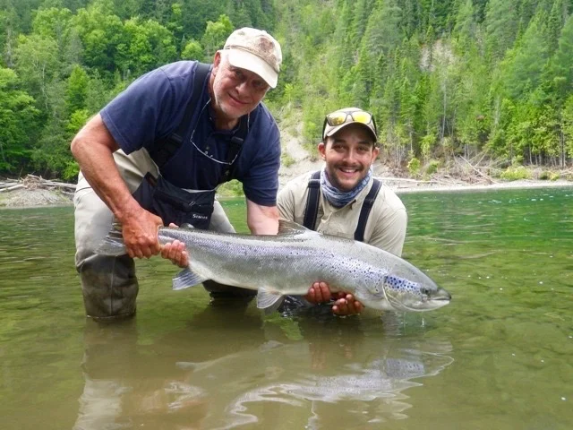 Long time Salmon Lodge guest, Claude Dagenais (left) releases a fine salmon on the Petite Cascapedia with Alex Mallais, the newest addition to our fine team of guides!