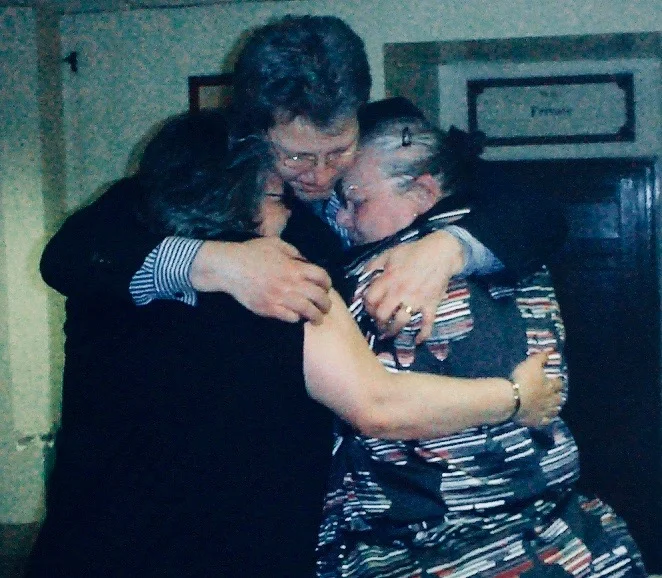 John Doe hugs his family after his conviction was quashed by the Court of Appeal