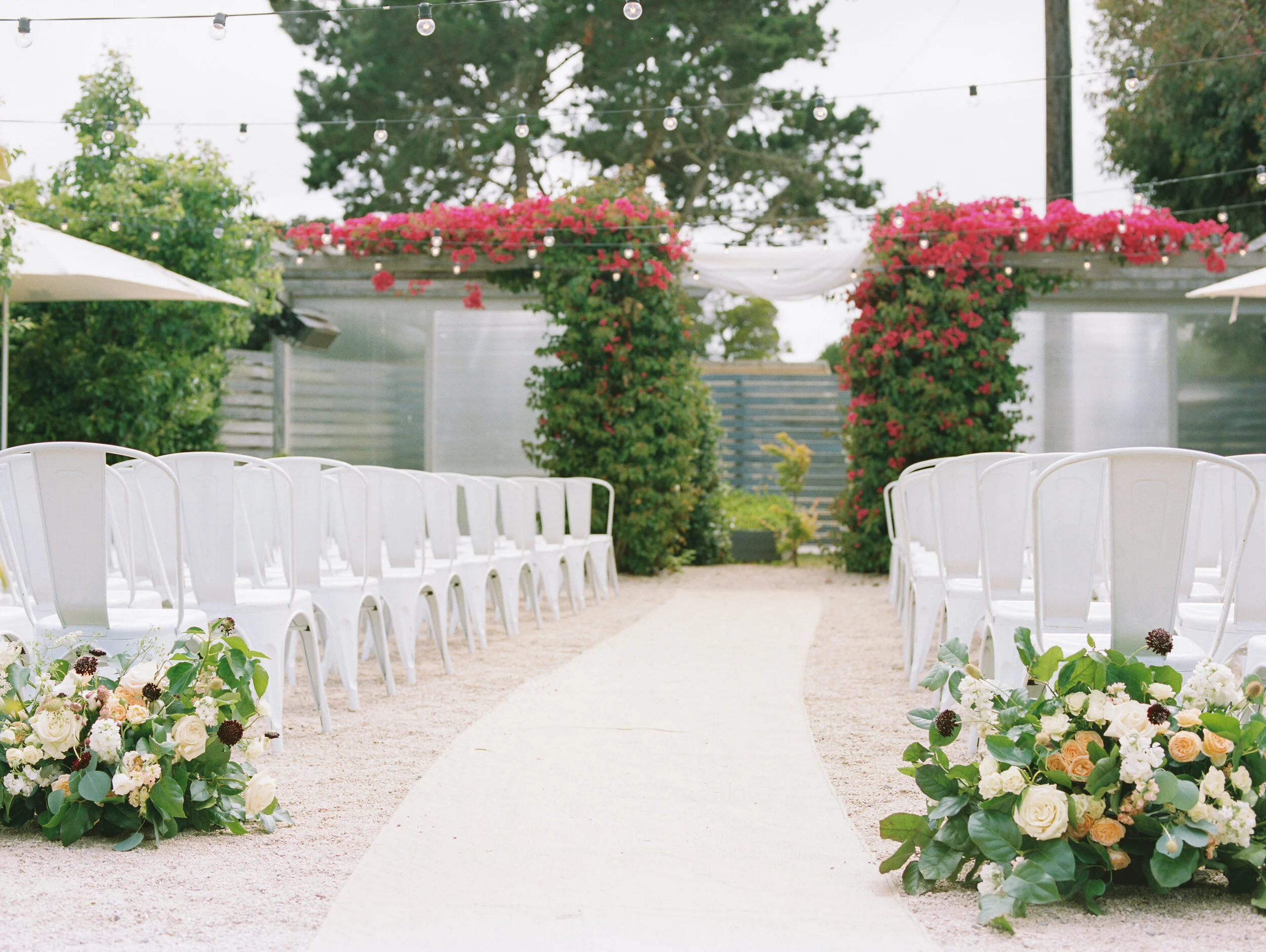 aracely cafe ceremony white industrial chairs bouganvilla aisle runner