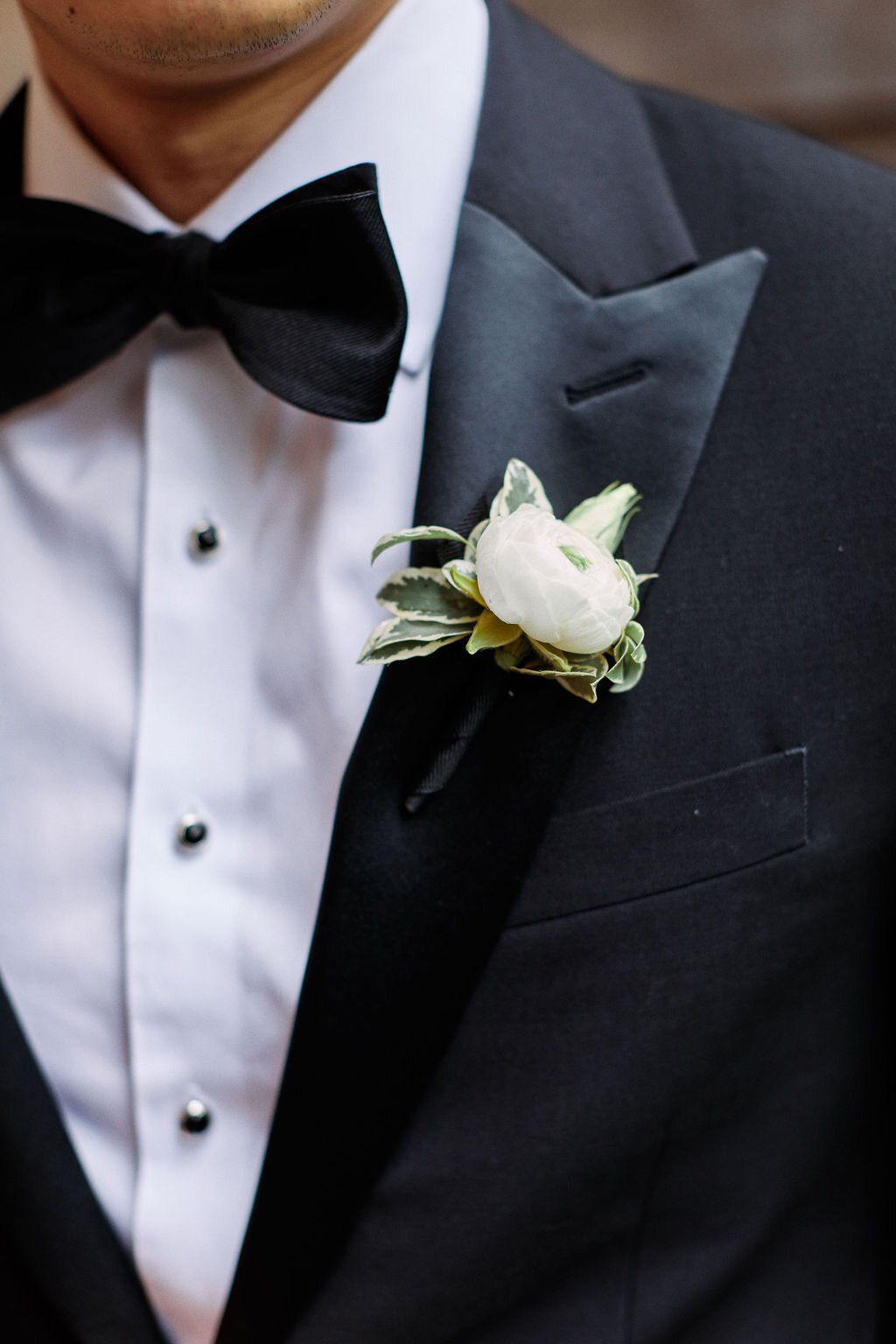 black tuxedo white boutonniere black bowtie