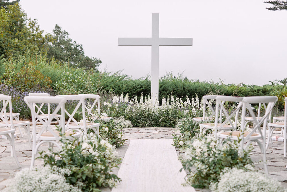 wedding ceremony white cross white rug aisle runner mixed white flowers