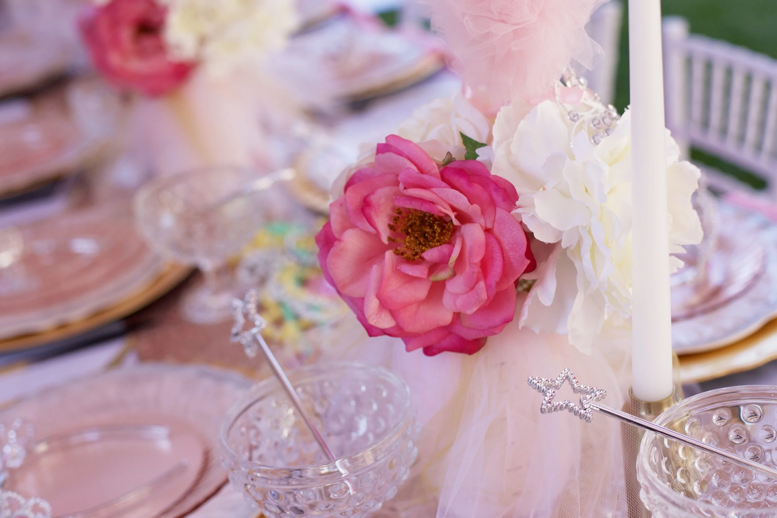 A rental collection with an elaborate ensemble of pink tutu centerpieces, white chiavari chairs, glittery runners, pink and white flowers, and sparkling tiaras that will dazzle even a Queen!
