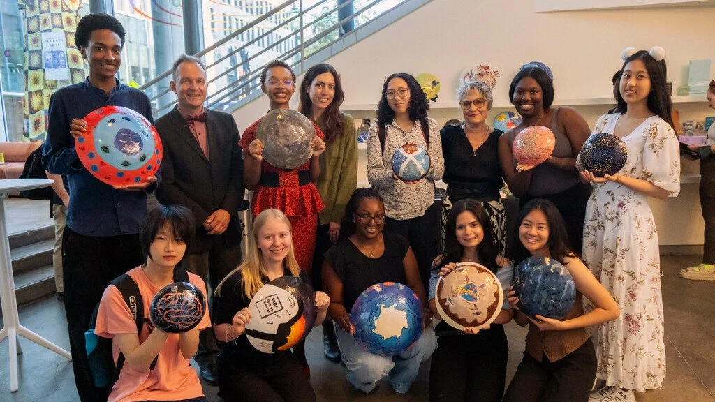 Group photo of students holding their painted shields