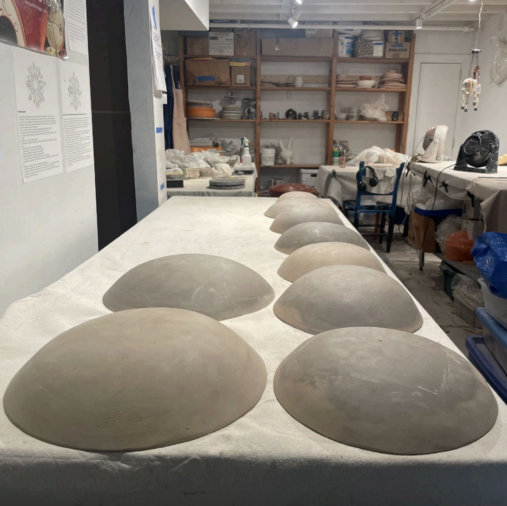 Unpainted clay shields on a table in a art workshop