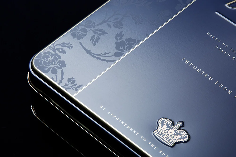 Danish Butter cookies – Metallic tin-packaging in royal blue and gold. Metallisk kagedåse I navyblå og guld