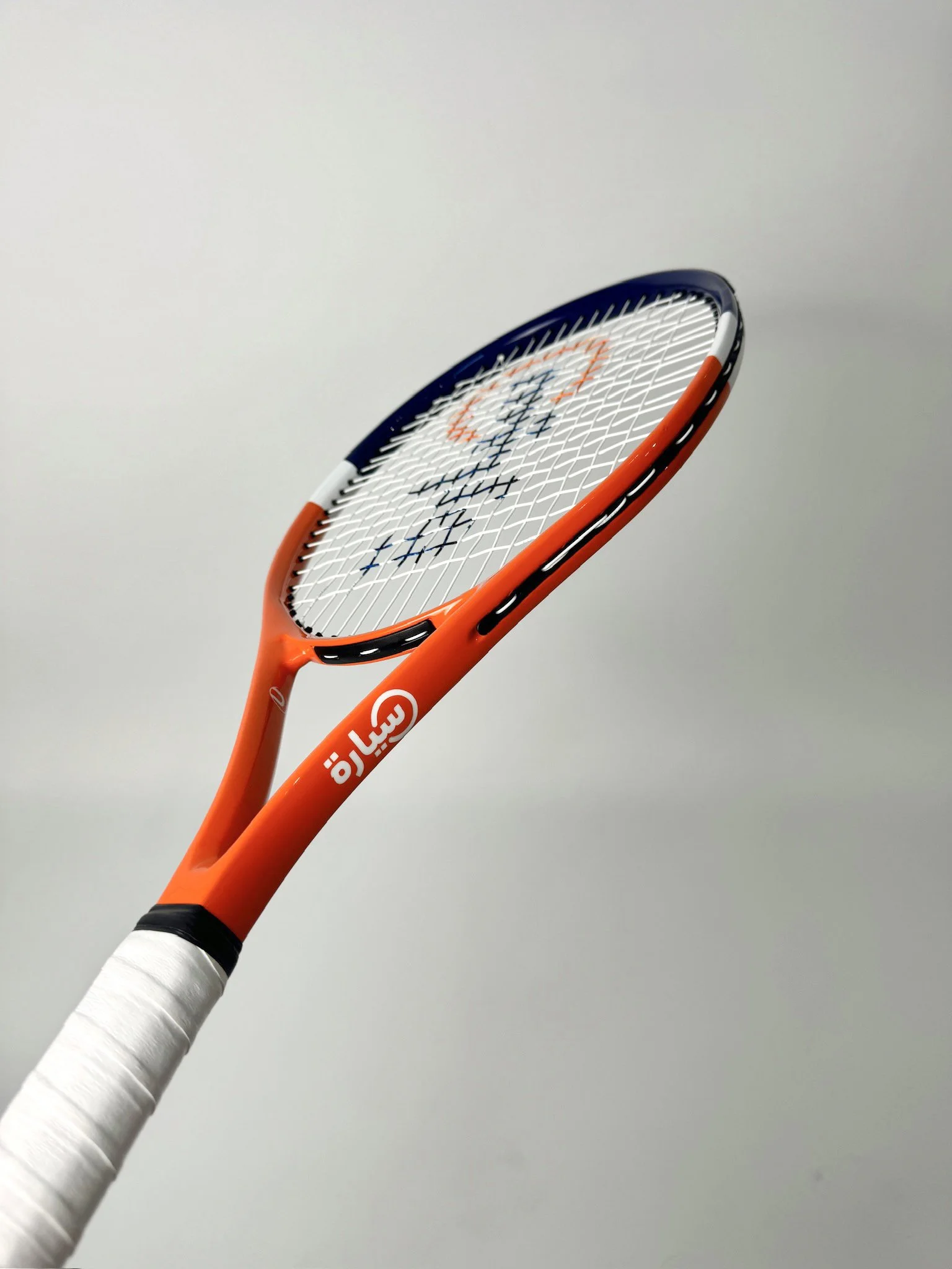 Orange tennis racket with white strings, featuring text on the frame.