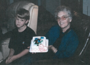 Pictured: T he author's brother and grandma, with a safe, store-bought cake. T he fact that we have no pictures of her in the kitchen helps prove the point that she was not immortalized there.