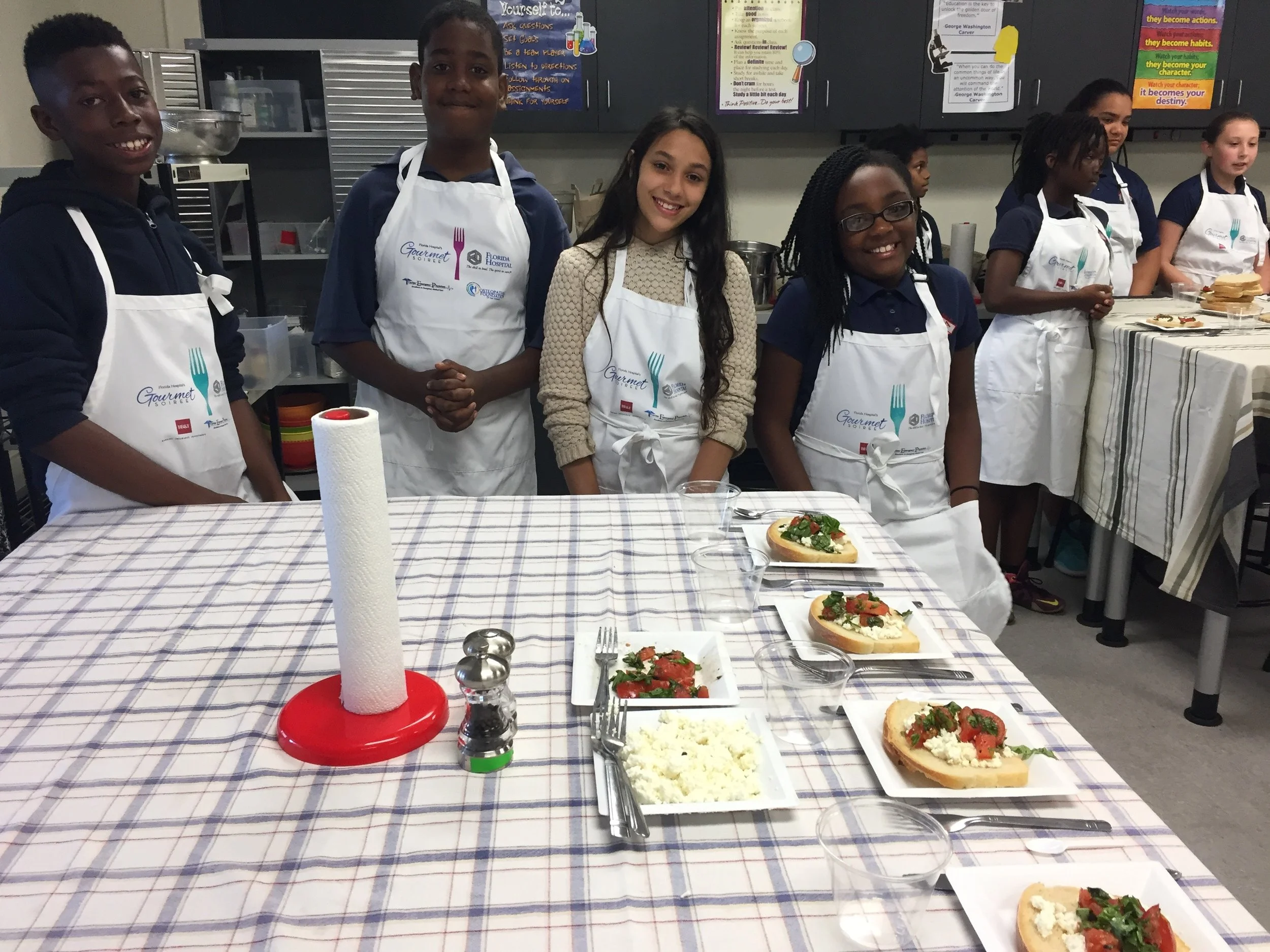 A 6th Grade team with their final product: homemade ricotta toasts with tomato and basil