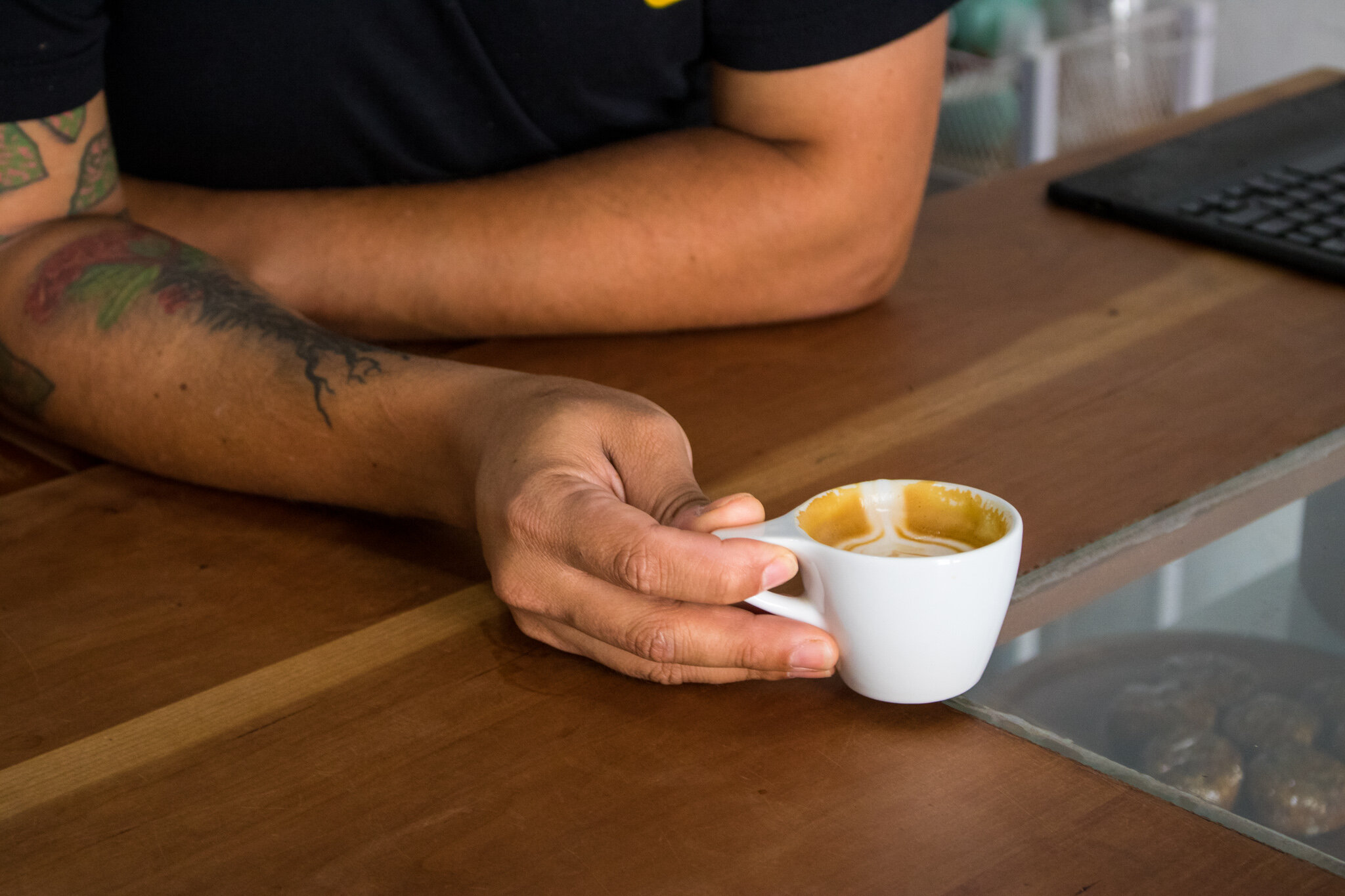  Enoc holds an espresso with milk.  