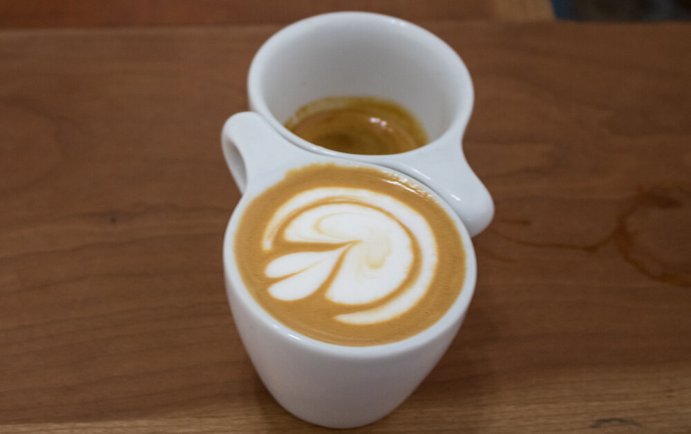  This is how baristas taste coffee. A double espresso in two cups, one with milk and one without, so it can be tasted both ways. 