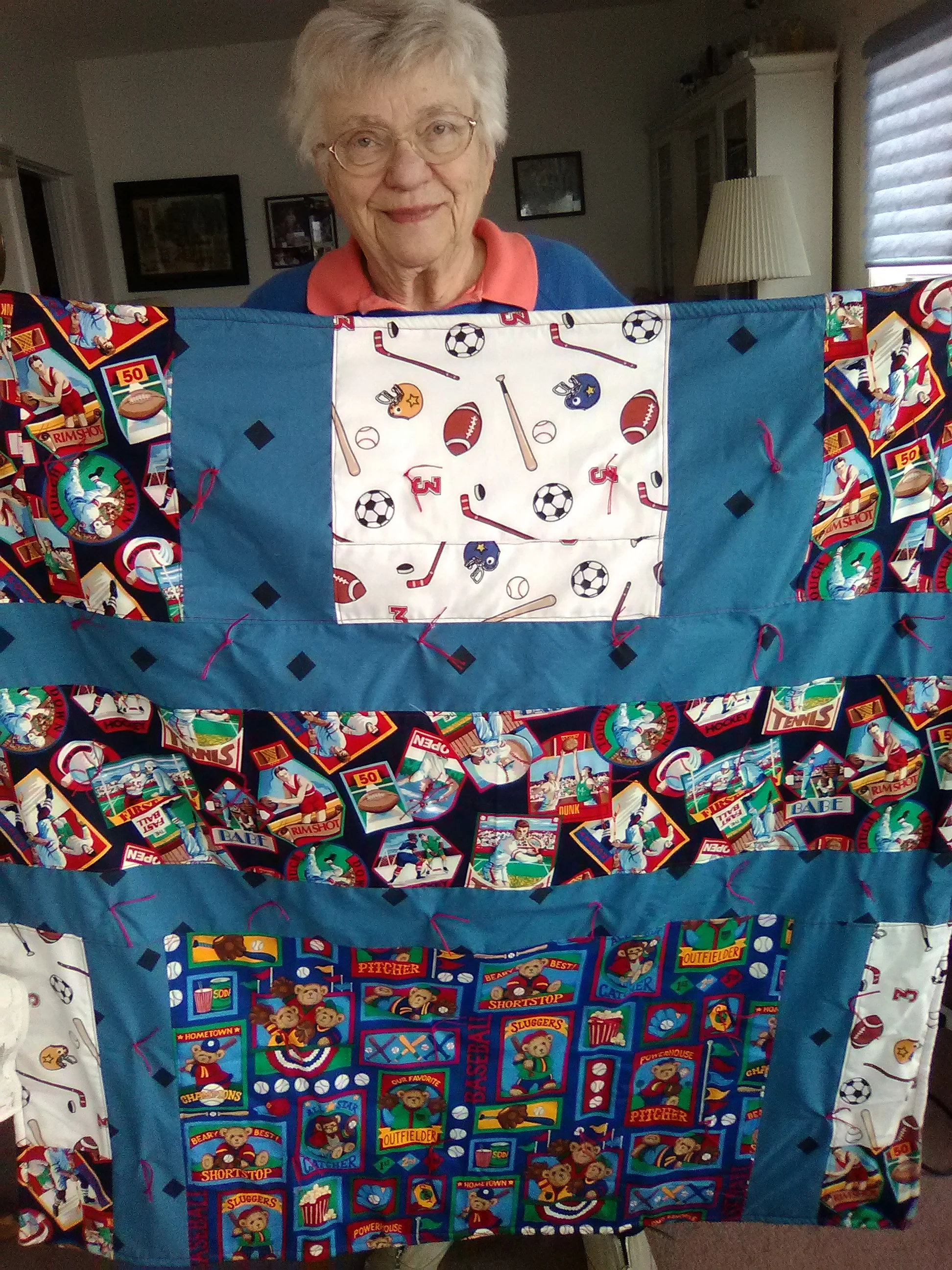 Above – Margaret Ebert with one of the many blankets she has made for use in care centers! Thank you!