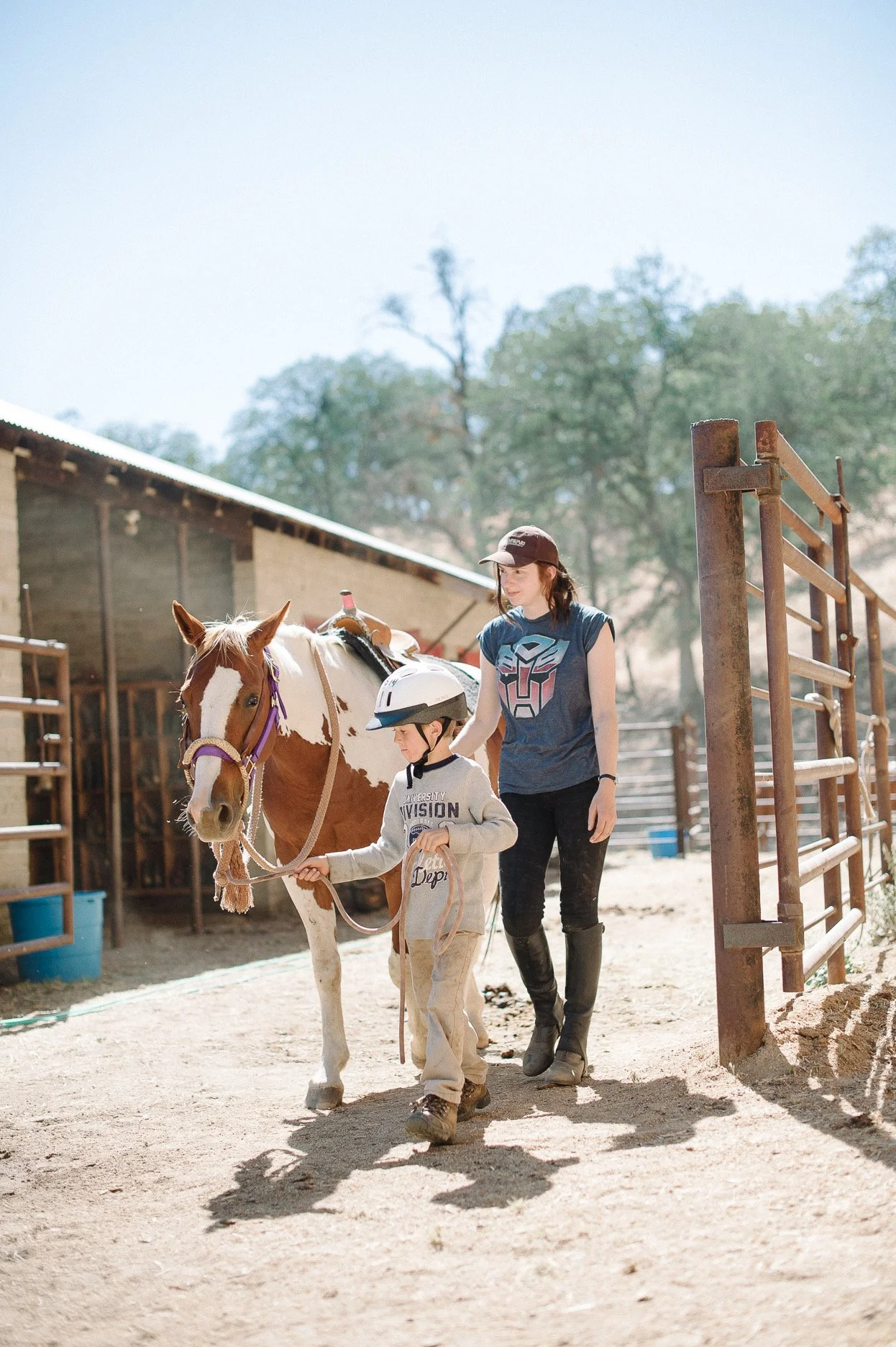 Camper walking a horse on at the barn at Jameson Ranch Camp — Western and bareback horsemanship program, 500+ acres, Glennville California