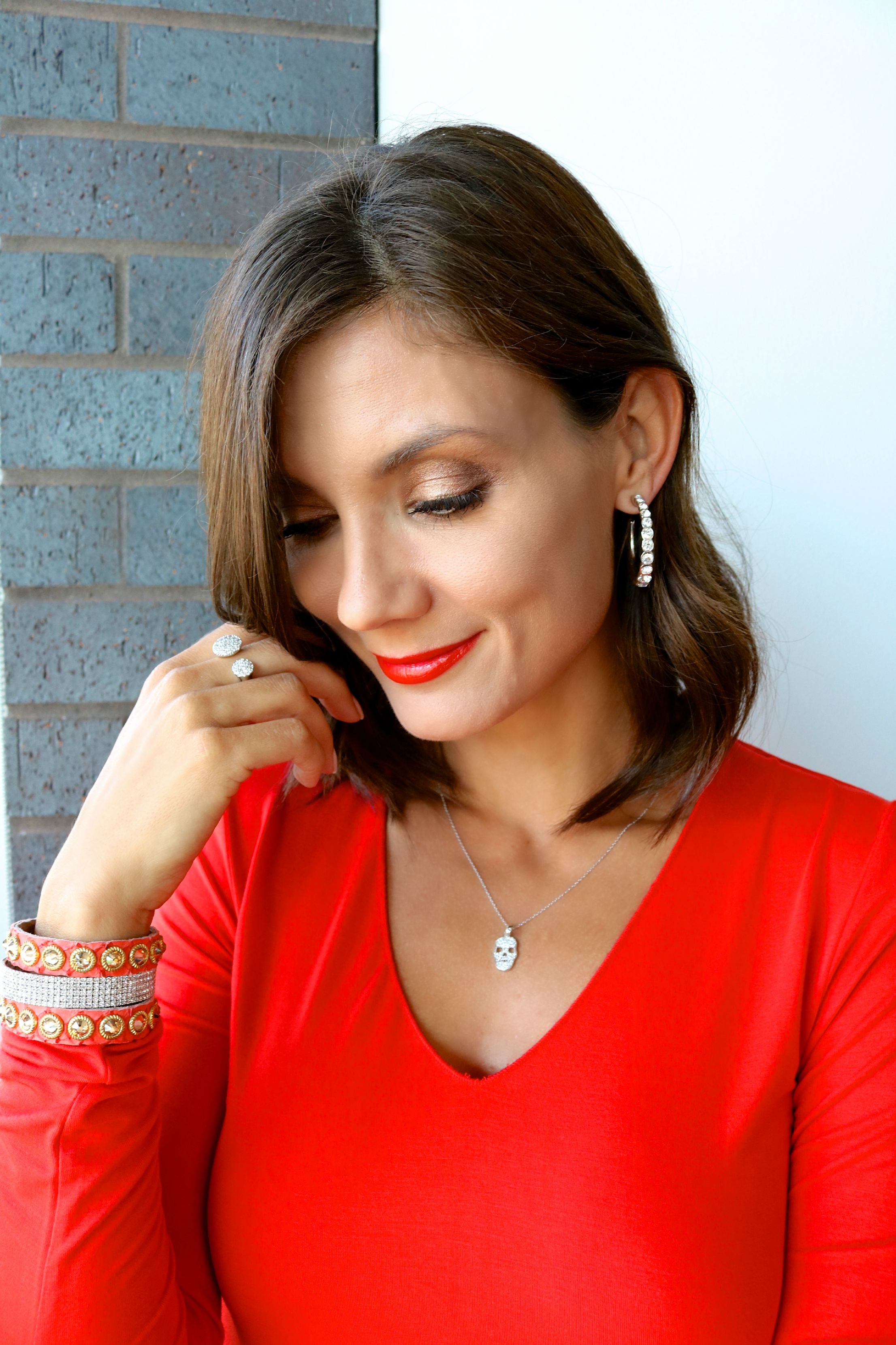 Judith Leiber Graduated Hoop Earring, Sun and Moon Ring in White Gold , Skull Necklace in White Gold, 5 Row CZ Bangle in Silver , Leatherock Stone and Studs on Python Leather in Salmon.