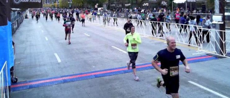 9.3 miles later. I DID IT! (Image description: Me crossing the finish line at the end of a 15k race in Chicago)