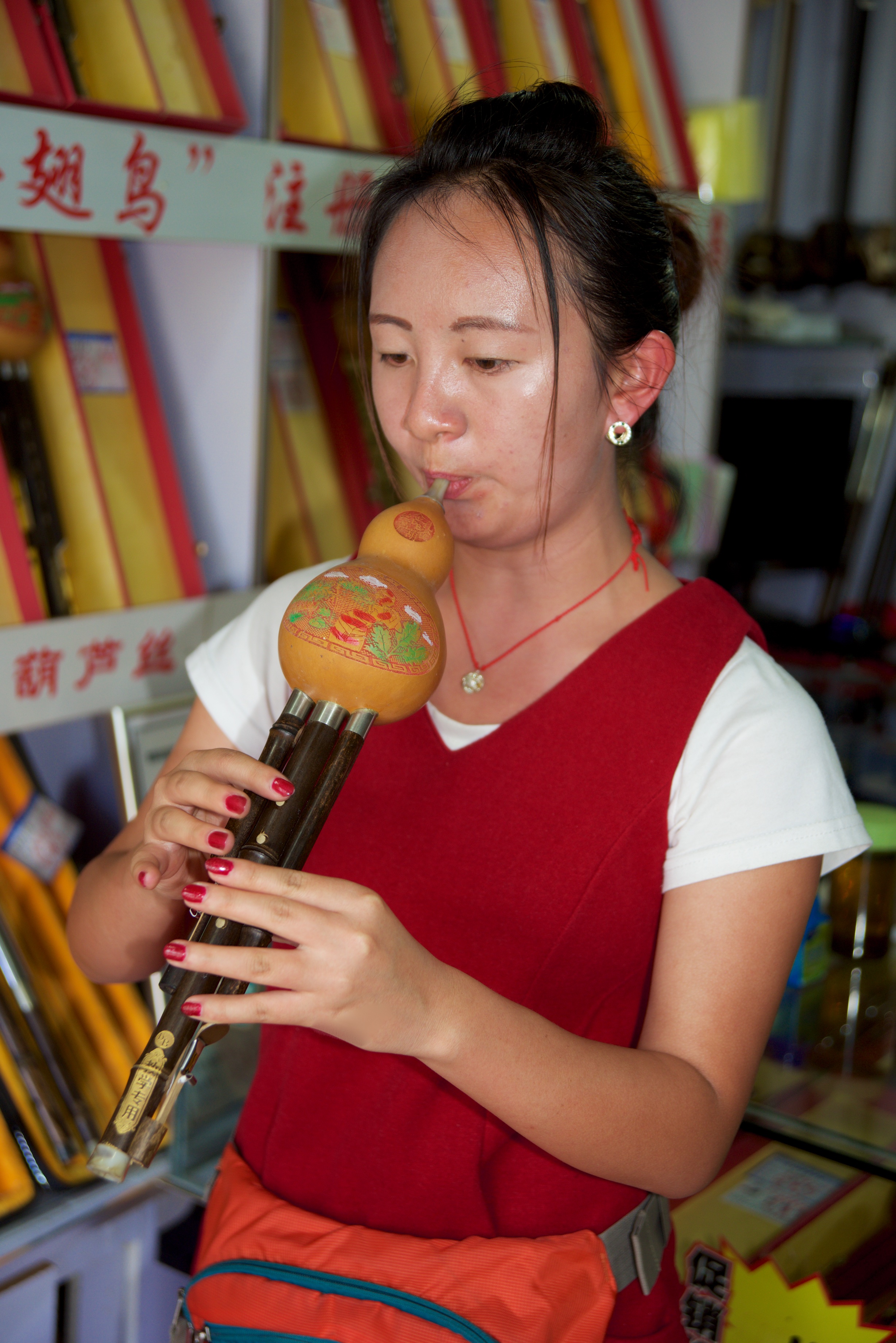 Girl (portrait shot) playing local instrument at market, Dali, China, 20 Jun 2015.jpg