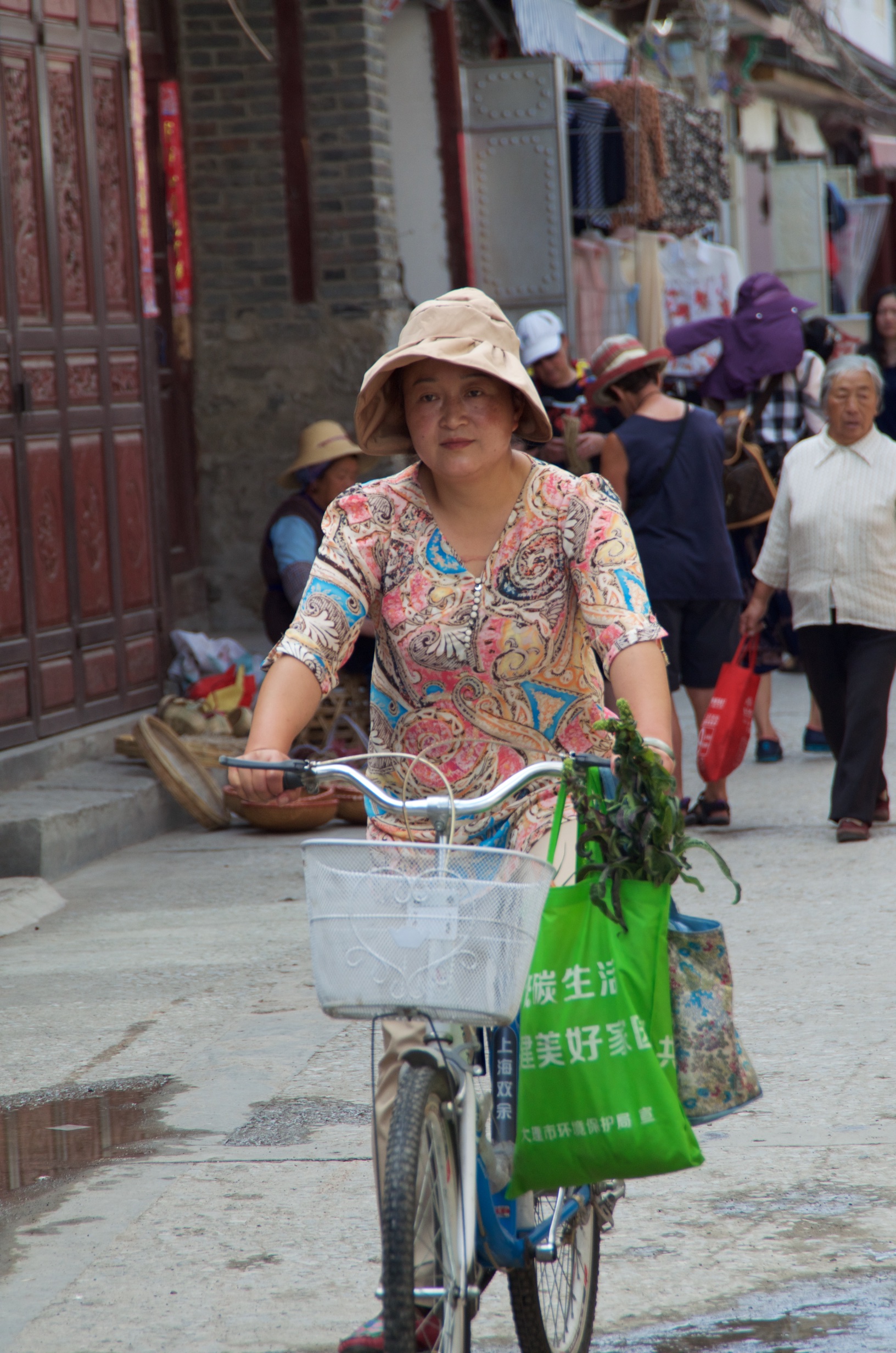  Lady riding bicycle in market, Bai village, Dali 