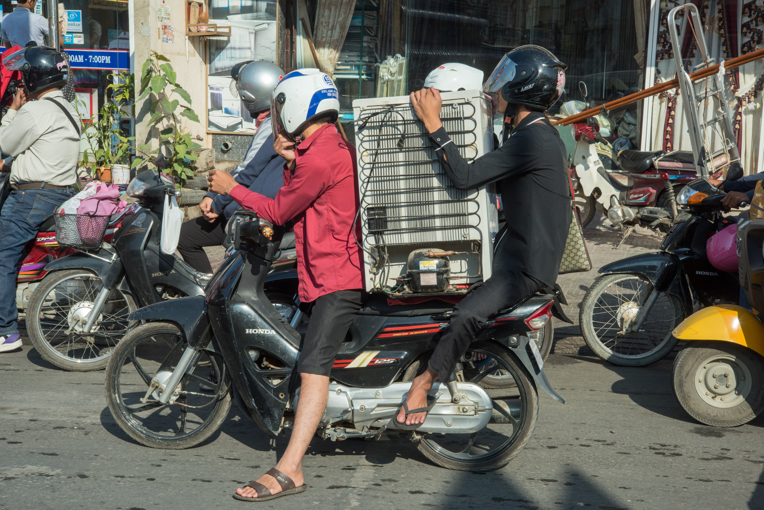Motorbike transporting bar fridge, Phnom Penh, Cambodia