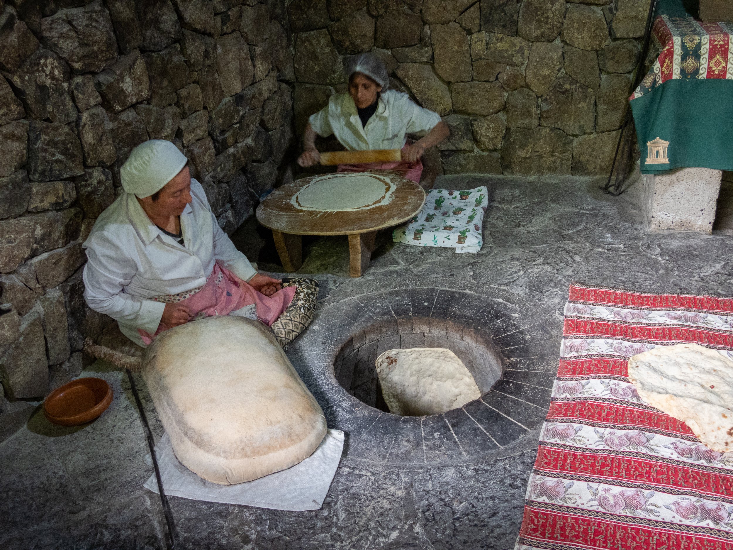 Women baking traditional Armenian flatbread “Lavash” in Tandoori oven, Garni Village, Armenia