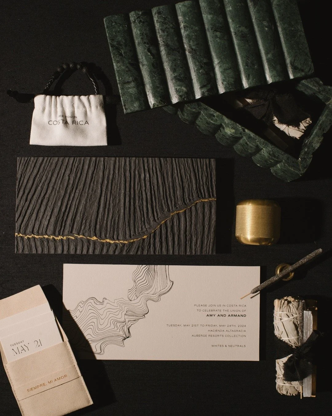 TACTILE LUXURIES // The invitation suite was housed in a sculpted green marble box, paired with palo santo sticks, a sage smudge bundle wrapped in black twine, and a gold match holder that added a metallic contrast to the natural stone. A suede pocke
