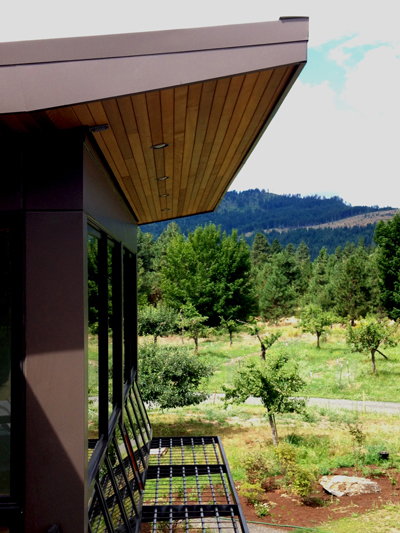 Red fabric shades will be installed over the metal canopies in the summer. Recessed lighting in the eaves will make the shades glow. Here the canopies are shadeless, in “snow load mode”.