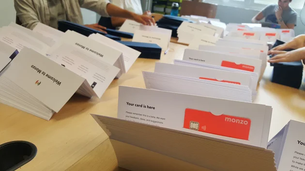 Monzo's coral-pink cards being packed. Photo: Monzo.