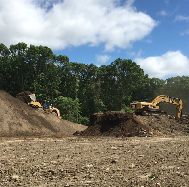 This excavator and loader are screening topsoil to prepare for grading the final design.