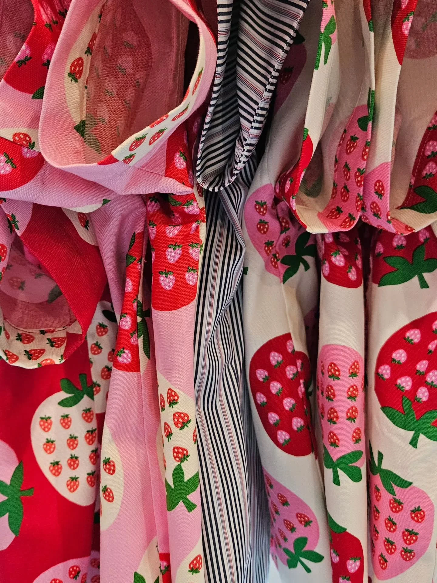 Under the needle 🪡 &amp; shipping out super soon! 🍓🍓🍓🍓🍓 Not shown here, a whole other pile (or two or three) of Strawberry fun. 

Working hard behind the scenes to get these special pieces to ya!  TY for your patience while we cut and stitch 💙