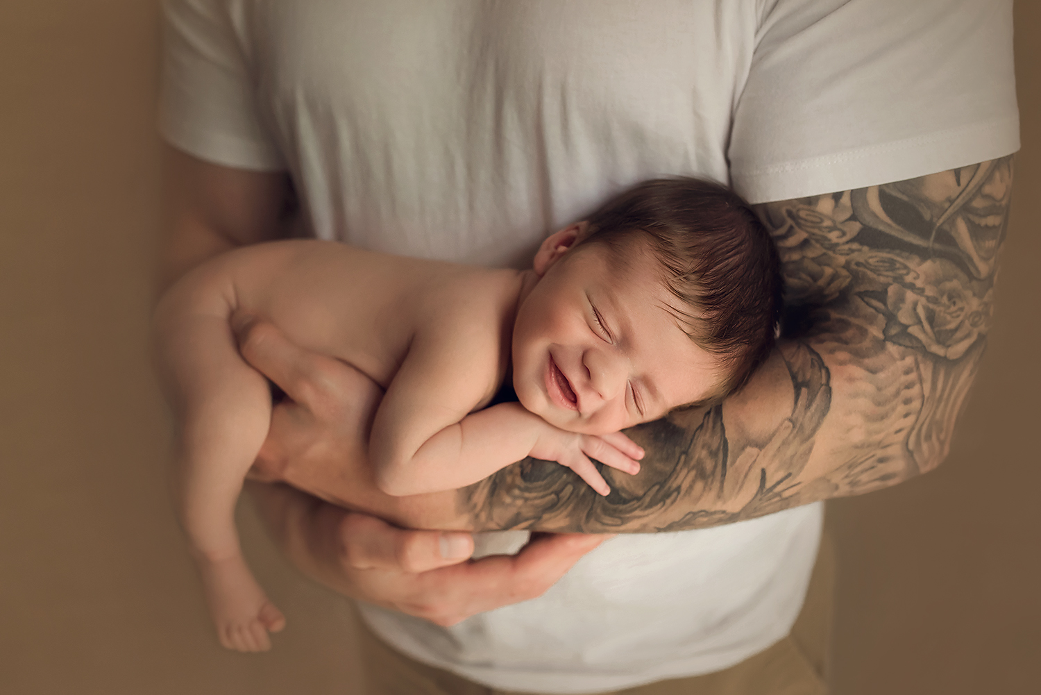 newborn baby boy smiling in dads arms, baltimore newborn photgrapher