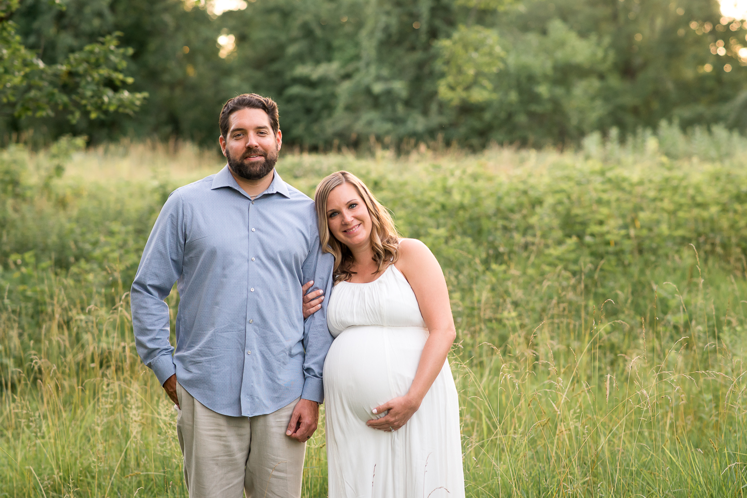 maternity photography pregnant woman in long white dress with husband in tall grasses Baltimore Photographer